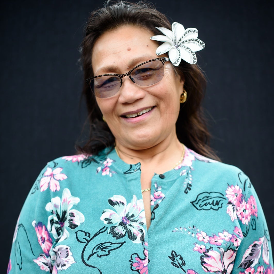 The artist in a floral shirt with a flower in her hair. 