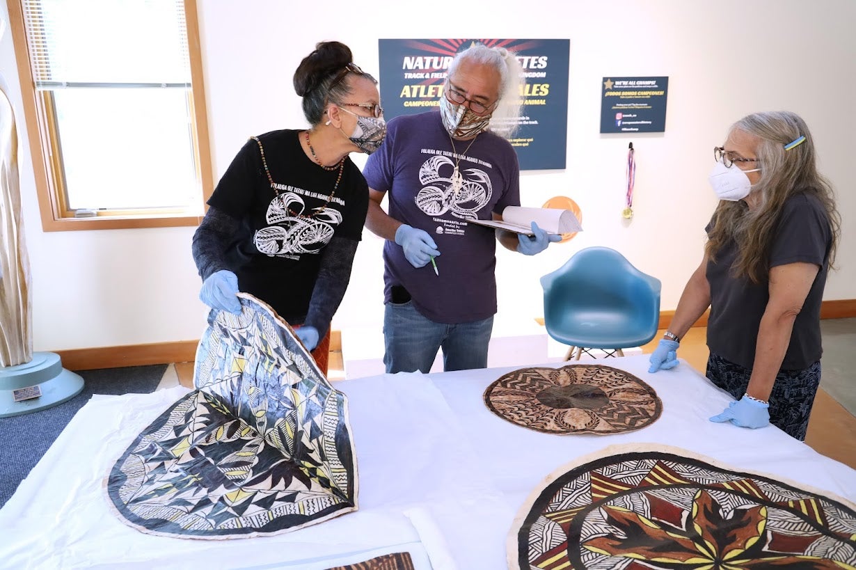 Reggie Meredith Fitiao and Su'a Ulisone Fitiao talk with collecitions director Pam Endzweig about round tapa cloths