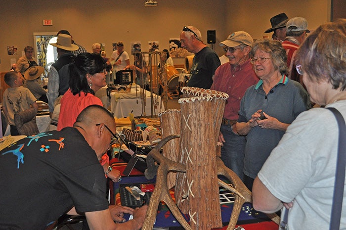 Artists tabling at an indoor fair.