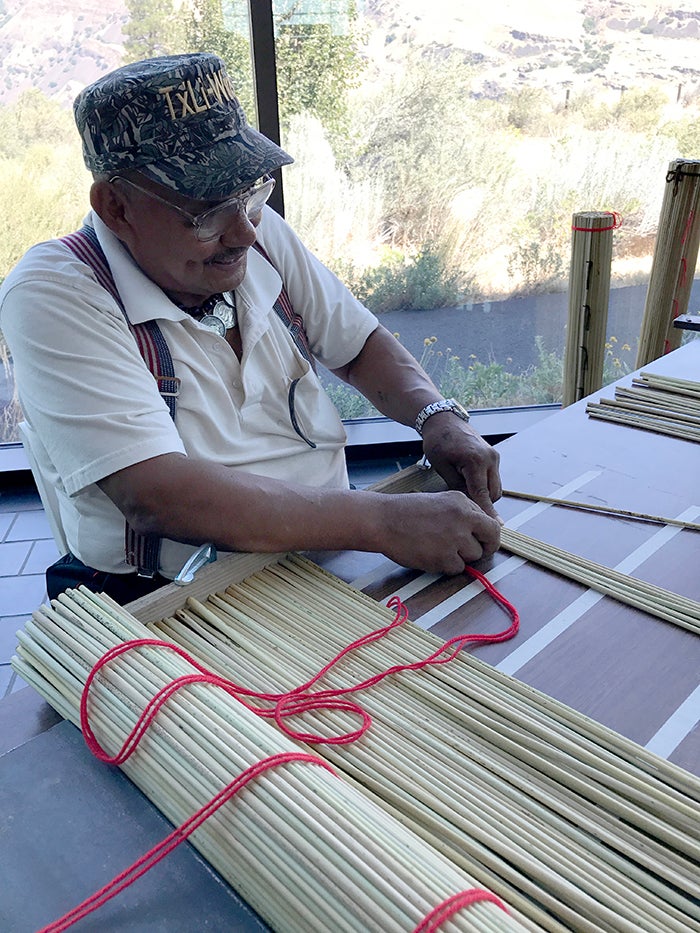 Taaw-Lee-Winch, known as "Tule Man," demonstrates the art of sewing tule mats