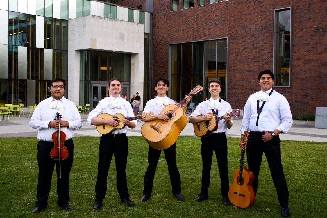 Jason stands in the middle of his student-run mariachi band.