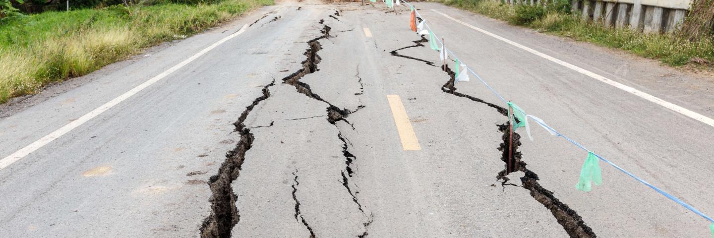 A road bisected by deep cracks from an earthquake.