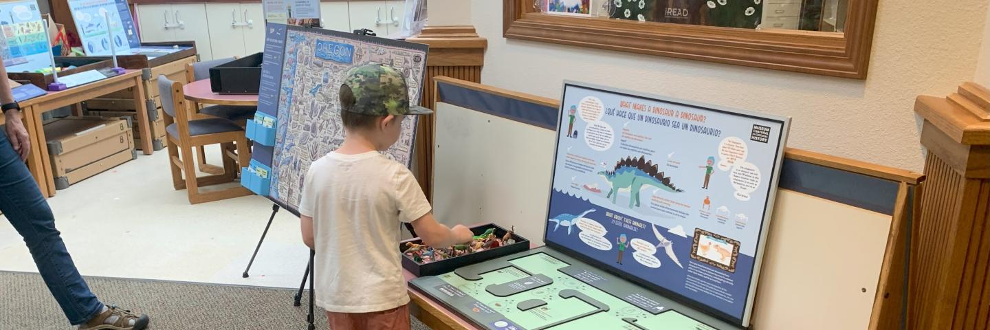 A kid plays with a dinosaur activity