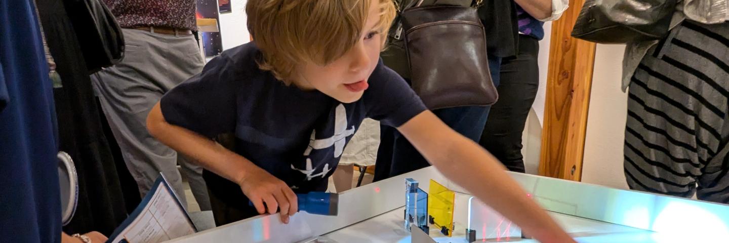 A child plays with a table investigating the properties of light