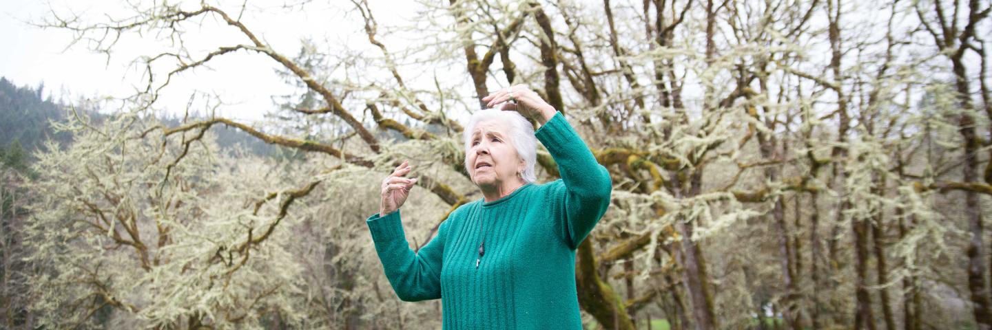 Esther Stutsman telling a story in a field surrounded by trees