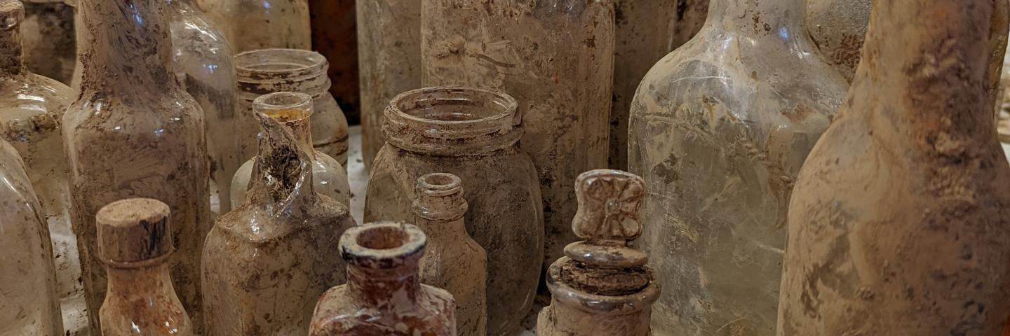 20 to 30 bottles crusted in dirt 