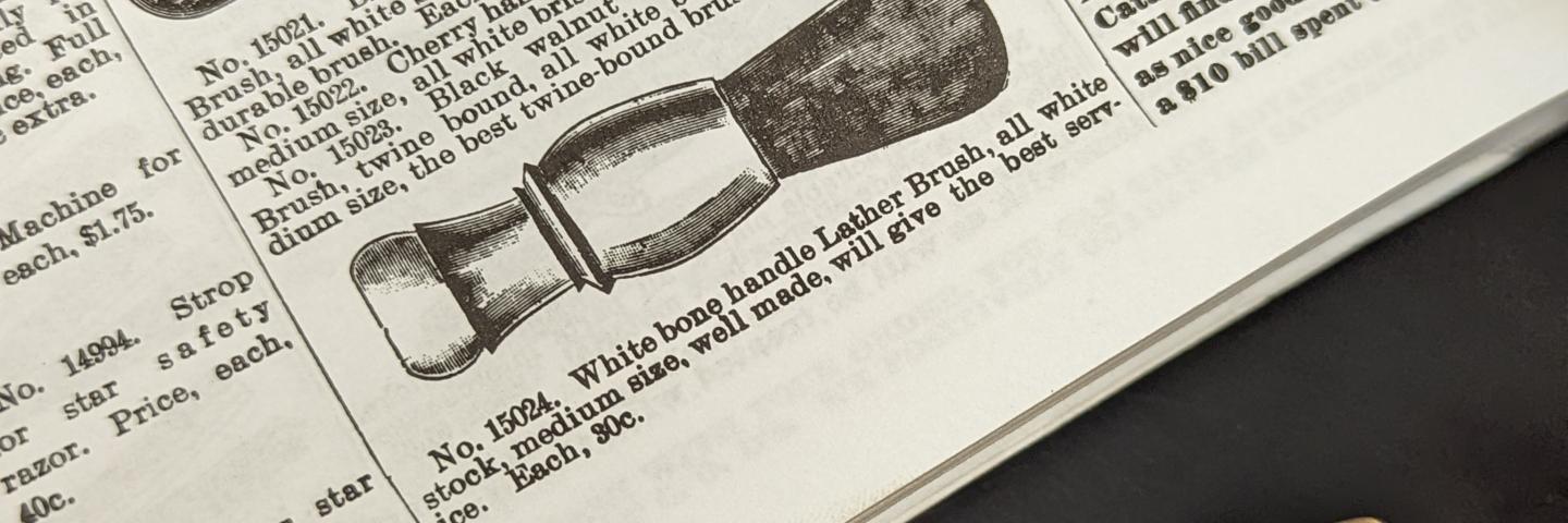 A light brown shaving brush handle next to a catalog page with a line drawing of a shaving brush handle