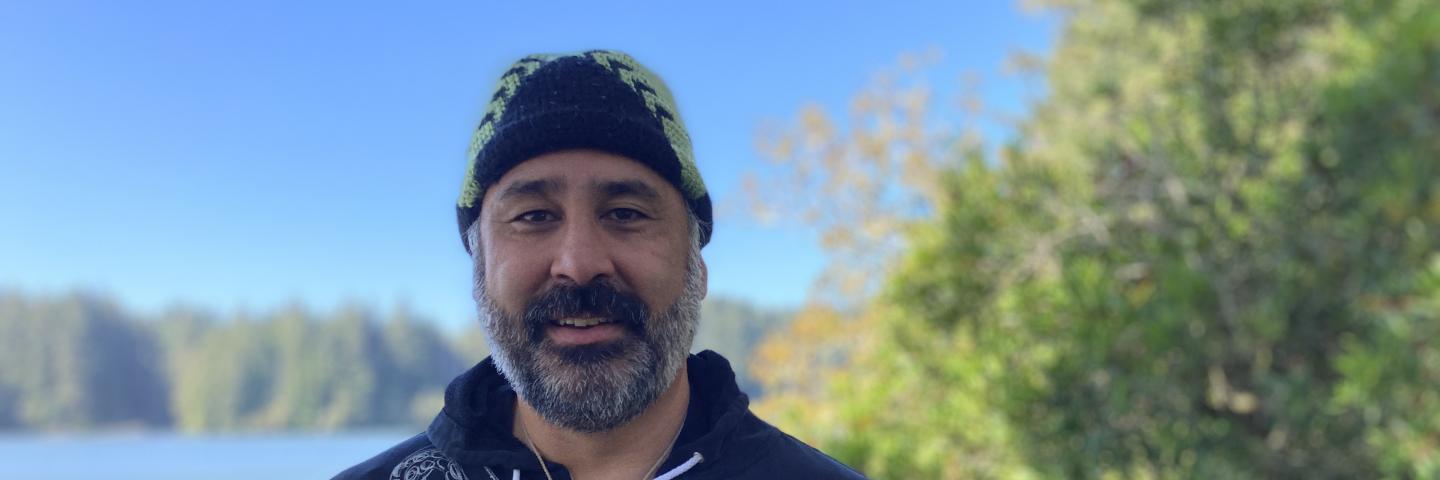 Shirod Younker stands in front of a river.