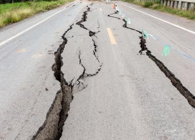 A road bisected by deep cracks from an earthquake.