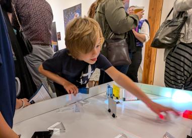 A child plays with a table investigating the properties of light