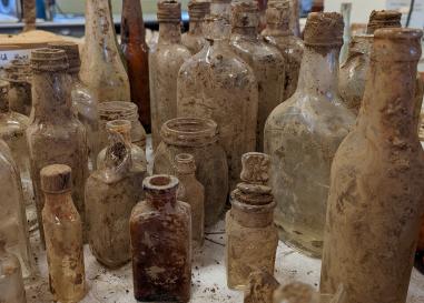 20 to 30 bottles crusted in dirt