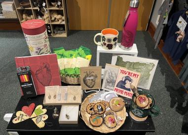 A table full of pink, red, and science-themed goods