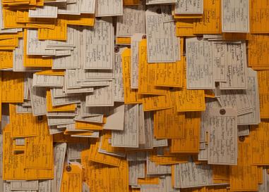 Close up view of overlapping white and orange and beige toe tags 