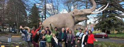 Group of people standing in front of a mammoth statue.