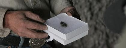 Close up of hands holding a box with an arrowhead in it