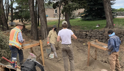 Four archaeologists work at a dig